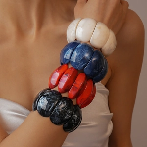 Detail of four chunky acrylic bracelets in marble pattern blue red white and black
