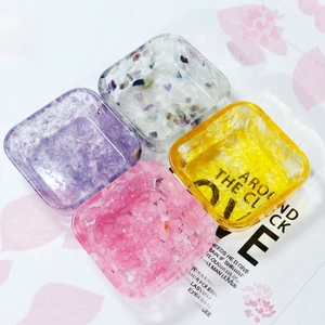 Set of four square resin crystal bowls in purple, pink, yellow and clear with gravel