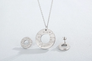 Detailed view of silver heart-shaped necklace and MOM engraved rhinestone earrings set