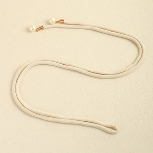 Detail of cream velvet waist belt featuring elegant gold metal tips and faux pearls