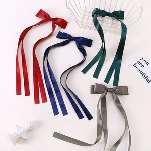 Detailed view of assorted long ribbon bow hair clips in satin fabric for children