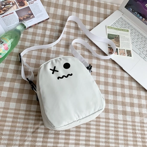 Détail du sac bandoulière blanc avec imprimé rigolo sur nappe à carreaux