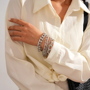 Detail shot of multi-layer silver metal chain bracelets worn on a female wrist