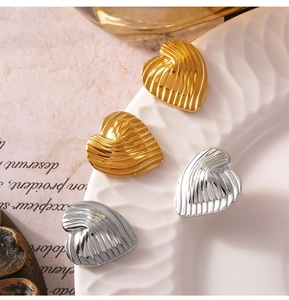 Detailaufnahme von Herzohrringen mit eleganter Wellenstruktur in Gold und Silberfinish