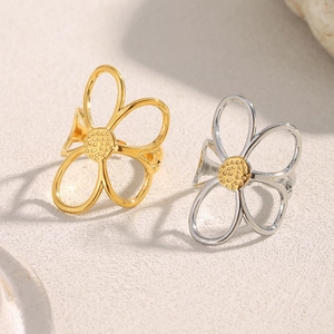 Macro shot of 18K gold and silver hollow flower rings with textured centers
