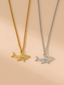 Detail view of 18k gold and silver shark pendant necklaces with delicate chains