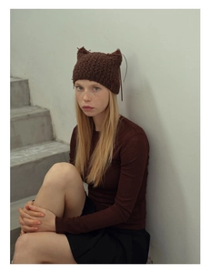 Detailed close-up of dark brown knit cat ear beanie featuring chunky handmade texture