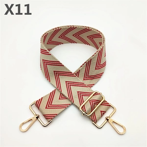 Detail of red and white chevron canvas bag strap with gold metal hooks and buckle