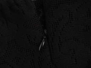 Macro shot of the invisible black zipper on lace hollow-out beach dress fabric