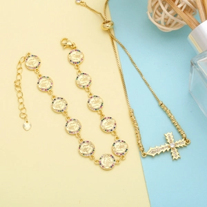 Detail of gold bracelets with colorful zircon medallions and rhinestone cross charm