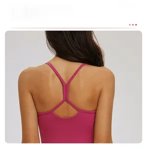 Gros plan des fines bretelles croisées d'un soutien-gorge de sport magenta en tissu élastique