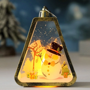 Macro shot of triangular bronze Christmas lantern with warm LED light and snowman scene