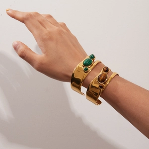 Gold stainless steel open bangle with malachite and tiger eye stones on wrist