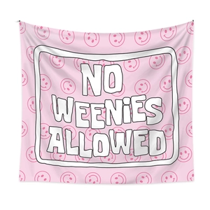 Detail of pink bohemian tapestry featuring smiley face pattern and No Weenies Allowed text