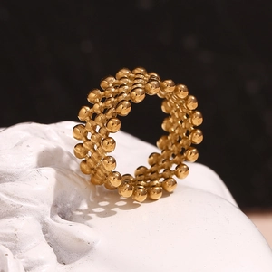 Detailed macro view of 18K gold plated beaded texture on a crossover fashion ring