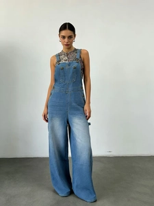 Détail d'une salopette en jean bleu clair à jambes larges avec boucles en métal