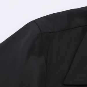 Detail of shoulder seam on black shirt dress with smooth synthetic fabric texture
