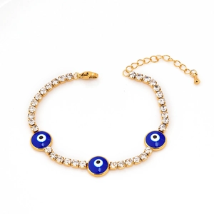 Golden Evil Eye bracelet with blue zircon and star charms on a white background