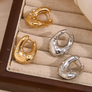 Detailed view of teardrop gold and silver hoop earrings with sparkling zircon stones