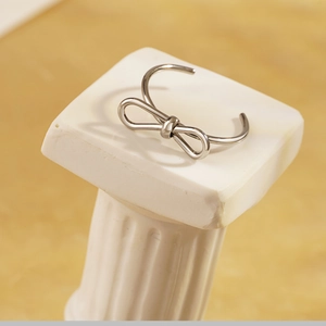Polierter silberner Schleifenknoten-Ring, offen und verstellbar auf einem Podest