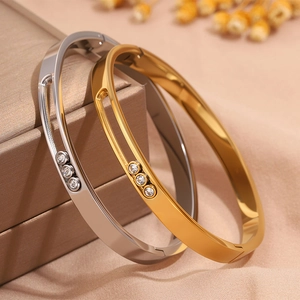 Detailed close-up of gold and silver steel bangles with three sliding zircon stones