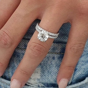 Elegant silver stacked moissanite rings set with main round stone on denim background