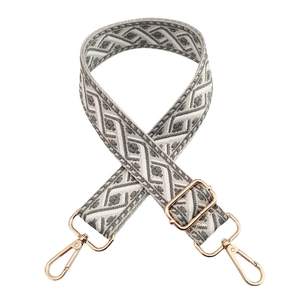 Detalle de correa tejida gris y blanca para bolso con hebilla de metal dorado ajustable