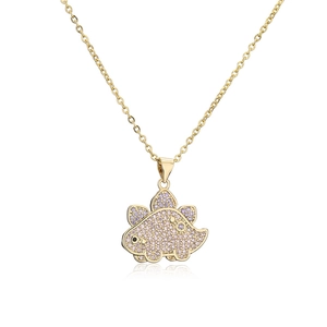 Macro shot of gold plated Stegosaurus pendant with purple zircon pavé and black eye detail