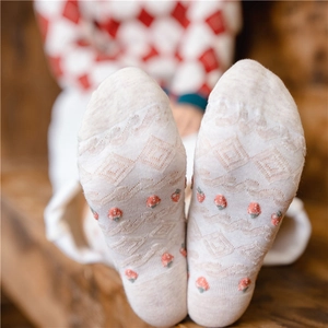 Close-up of strawberry embroidery and diamond pattern on cotton crew socks