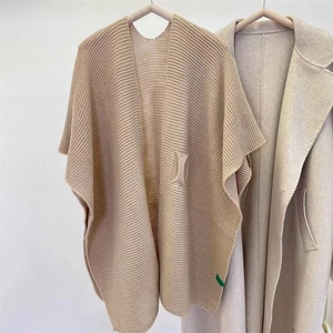 Knitted beige shawl wrap with ribbed texture and minimalist cape style for autumn
