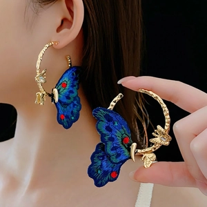 Orecchini a cerchio dorati con farfalle ricamate blu e accenti di perline colorate