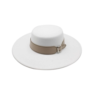 Détail d'un chapeau en laine blanc avec bande en cuir camel et boucle en métal