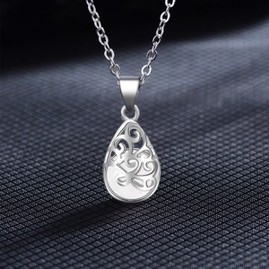 Macro detail of teardrop hollow pendant with vintage silver engraving and crystal inlay