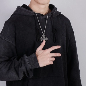 Close-up of vintage Celtic knot cross pendant with twisted chain on black hoodie