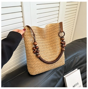 Detailed shot of rainbow straw bucket bag with dark wood beads and brown handle
