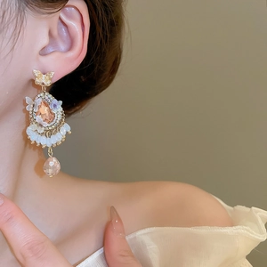 Close-up of vintage gold tassel earrings with crystal pendants and white bead fringe