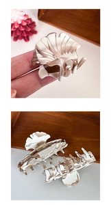 Detail of marble pattern acetate hair claw clip showing seashell design and spring texture