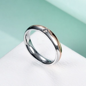 Detail of silver stainless steel ring featuring a rose gold line and a sparkling inlaid stone