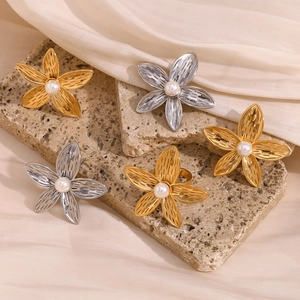 Detail of 18K gold and silver frangipani flower rings with white pearl centers