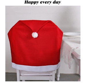Detail of red velvet Christmas chair cover with white plush pompom and trim decor