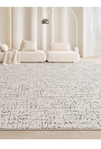 Close-up of white cream-style rug with abstract black dot pattern on wooden floor