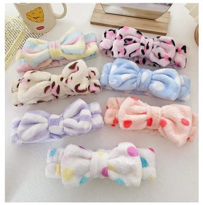 Flat lay of colorful plush bow headbands with rainbow, leopard, and polka dot patterns