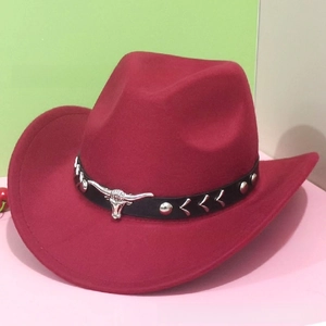 Detail of dark red felt cowboy hat featuring black leather band and silver bull head icon