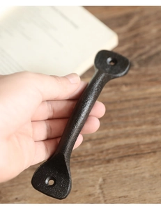 Detailansicht eines gusseisernen Türgriffs im Vintage-Stil mit schwarzer Sandstrahltextur