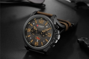 Close-up of Curren men's chronograph watch dial with brown leather strap and date display