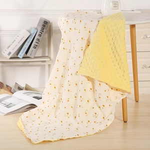 Detail of baby blanket showing yellow floral cotton gauze and 3D minky fabric texture