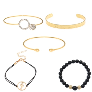 Gedetailleerde set van 5 gouden armbanden met strassteentjes en zwarte kralen textuur