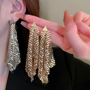 Vue de près de boucles d'oreilles à pampilles en maille de sequins argentés et dorés