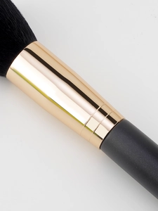 Close-up of soft black bristles with gold ferrule and matte handle of the makeup brush
