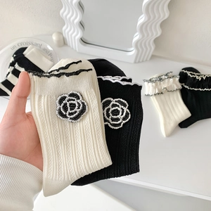 Lolita style knit socks featuring 3D camellia floral beads and ruffled edges in black and white